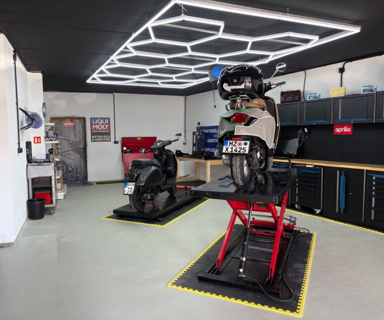 Vespa auf Hebebühne mit Werkzeugschränken und LED-Beleuchtung bei Dolce Vita Garage in Wörrstadt